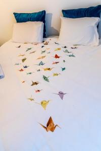 Una cama con pájaros de origami volando a su alrededor. en B&B 1 uit de 100, en Gante