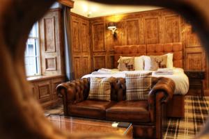 una camera con letto e divano in pelle di The Golden Fleece Inn a Porthmadog