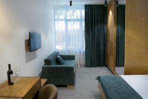 Camera con divano, sedia e TV di R&R Hotel a Yerevan