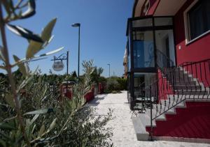 um passeio ao lado de um edifício vermelho com escadas em Guest House DOLCE LAGUNA 2 em Tessera