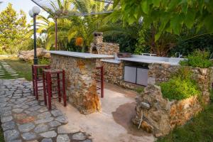 una barra de piedra en un jardín con dos taburetes en Ktima Petalea, en Gythio