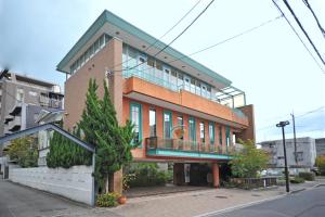 ein Backsteingebäude mit Balkon auf einer Straße in der Unterkunft villa garden DaiDai in Hiroshima