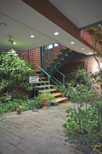 ein Gebäude mit einer Treppe im Hintergrund mit Pflanzen in der Unterkunft villa garden DaiDai in Hiroshima