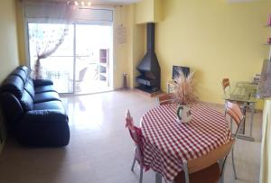 een woonkamer met een tafel en een bank bij Magnífico apartamento junto al canal principal. in Empuriabrava