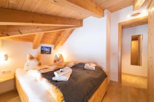 een slaapkamer met een bed in een kamer met houten plafonds bij Ferienhaus Gundi in Pettneu am Arlberg