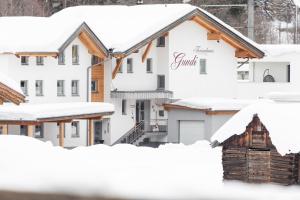 een rij huizen bedekt met sneeuw bij Ferienhaus Gundi in Pettneu am Arlberg