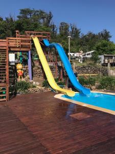 uno scivolo blu e giallo in un parco giochi di Complejo Laderas del Cerro a Piriápolis