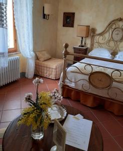 um quarto com uma cama e uma mesa com flores em Agriturismo Borgo La Casetta em San Baronto