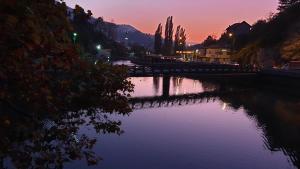 uma ponte sobre um rio ao pôr-do-sol em Pansion River em Saraievo