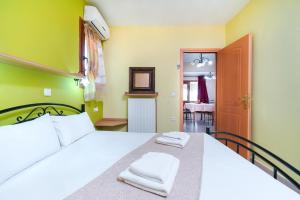 1 dormitorio con 1 cama blanca y 2 toallas en Villa Golden Nest, en Limenaria