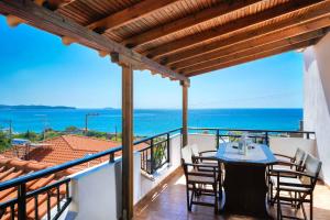 una mesa y sillas en un balcón con vistas al océano en Villa Golden Nest, en Limenaria