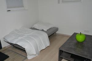 een bed in een kamer met een groene appel op een tafel bij Apartment in Reutlingen / Sickenhausen in Reutlingen