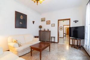 a living room with a white couch and a tv at San Marco 4893 in Venice