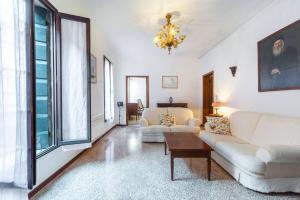 a living room with white furniture and a chandelier at San Marco 4893 in Venice