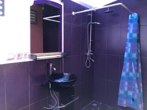 a purple bathroom with a sink and a shower at The Papalagi Resort in Gili Gede