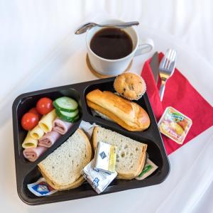 - un plateau noir avec des sandwichs et une tasse de café dans l'établissement AirPark Balice, à Balice