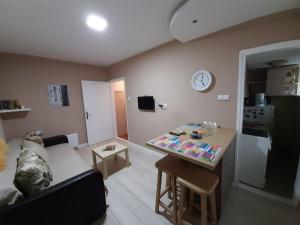 Il comprend un salon avec un canapé et une cuisine avec une table. dans l'établissement Apartman Ana, à Šabac