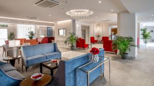 a living room with blue furniture and red chairs at Hotel American Palace Eur in Rome