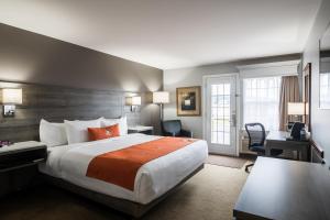 een hotelkamer met een groot bed en een bureau bij Amsterdam Inn & Suites Moncton in Moncton