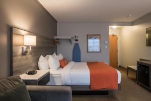 een hotelkamer met een bed en een bank bij Amsterdam Inn & Suites Moncton in Moncton