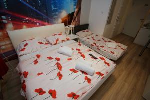 um quarto com duas camas com flores vermelhas em Apartments Rooms FONTANE TRNJE - FREE PARKING em Zagreb