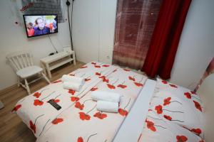 um quarto com uma cama com flores vermelhas em Apartments Rooms FONTANE TRNJE - FREE PARKING em Zagreb