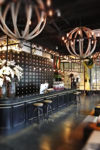 un ristorante con bar con sgabelli e fiori di M Boutique Hotel a Ipoh