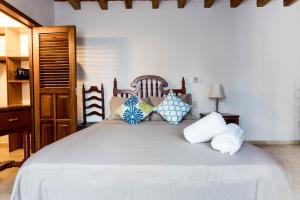 een slaapkamer met een groot wit bed met kussens bij Olas Altas Suites Departamentos in Puerto Vallarta