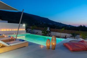 a villa with a swimming pool at night at PAROS ELITAS VILLAS in Parikia