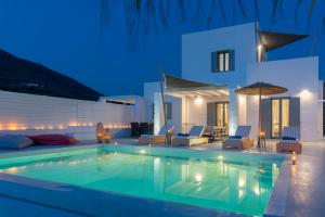 a swimming pool in front of a villa at night at PAROS ELITAS VILLAS in Parikia