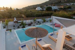 a swimming pool with an umbrella and chairs and a pool at PAROS ELITAS VILLAS in Parikia