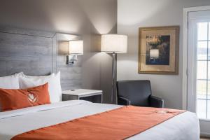 een hotelkamer met een bed en een stoel bij Amsterdam Inn & Suites Moncton in Moncton