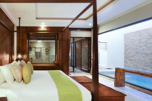 a bedroom with a bed and a large window at Nunamkhalu Private Villa and Spa in Nusa Dua