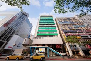 une voiture jaune garée devant un grand bâtiment dans l'établissement Green World ZhongXiao, à Taipei