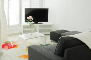 a living room with a tv and a vase with a flower at Boarding-Potsdam in Potsdam