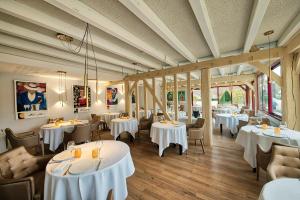 ein Esszimmer mit weißen Tischen und Stühlen in der Unterkunft Auberge du Lac Hôtel & Spa Restaurant Gastronomique in Mesnil-Saint-Père