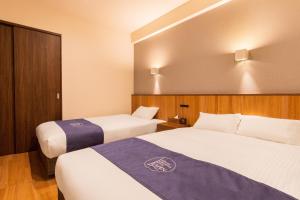 A bed or beds in a room at LAPIN MIHAMA Residence Hotel