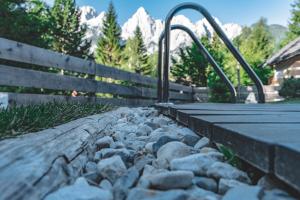 een loopbrug met rotsen en een hek en bergen bij Hiša Katja-Privat wellness in Kranjska Gora