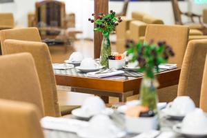 een houten tafel met bloemen in vazen erop bij Legendary Lisboa Suites in Lissabon