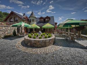 ein Restaurant mit einer Terrasse mit Tischen und Sonnenschirmen in der Unterkunft Zámeček Kaliště in Poddubí