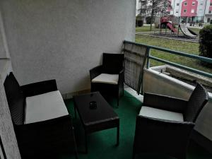 einen Balkon mit Stühlen, einem Tisch und einem Spielplatz in der Unterkunft Ferienwohnung Dado in Eisenstadt