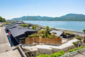 een luchtzicht op een gebouw naast een waterlichaam bij 宮島離れの宿 IBUKU 別邸 -Miyajima Hanarenoyado IBUKU Bettei- in Ōno