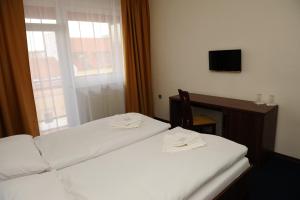 um quarto de hotel com duas camas e uma televisão em Hotel Zobor em Nitra