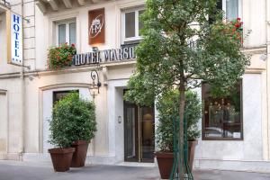 ein Gebäude mit Topfpflanzen vor einem Laden in der Unterkunft Louvre Marsollier Opera in Paris