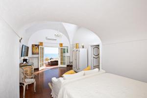 una camera bianca con letto e soggiorno di La Casa di Peppe a Positano