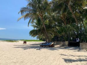 duas pessoas sentadas num banco na praia em Mombasa Vacations Beach Studio B11 em Mombaça