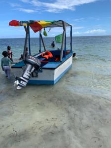 um barco com um guarda-sol na praia em Mombasa Vacations Beach Studio B11 em Mombaça