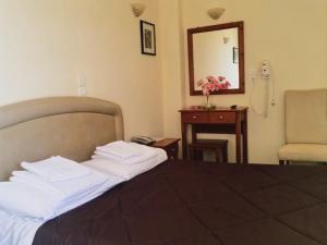 um quarto de hotel com uma cama e um telefone em Ξενοδοχείο "Ηραία" em Iamatikes Piges