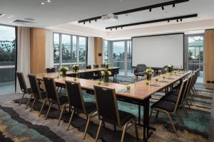 une salle de conférence avec une grande table et des chaises ainsi qu'un tableau blanc dans l'établissement Crystalbrook Bailey, à Cairns