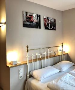 - une chambre avec un lit et 2 photos sur le mur dans l'établissement Hotel Alexander, à Wiesbaden